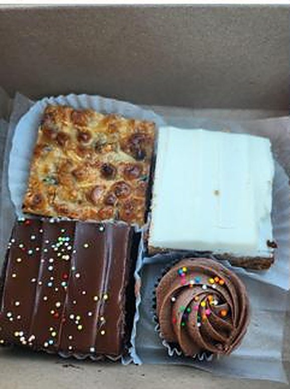 Brownies, squares and a cupcake in a bakery box